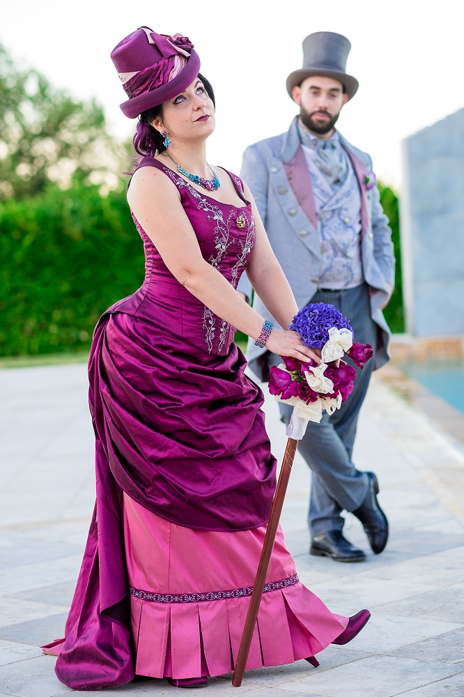 Sposi in stile tardo vittoriano, abito da sposa fucsia e rosa, abito da sposo grigio