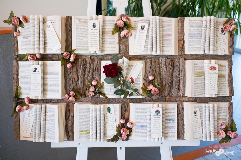 Un tableau de mariage romantico, con una rosa al centro e libri per segnare i tavoli