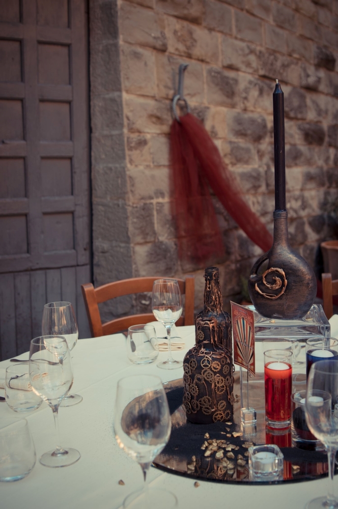 A steampunk centerpiece made with black bottles with bronze gears