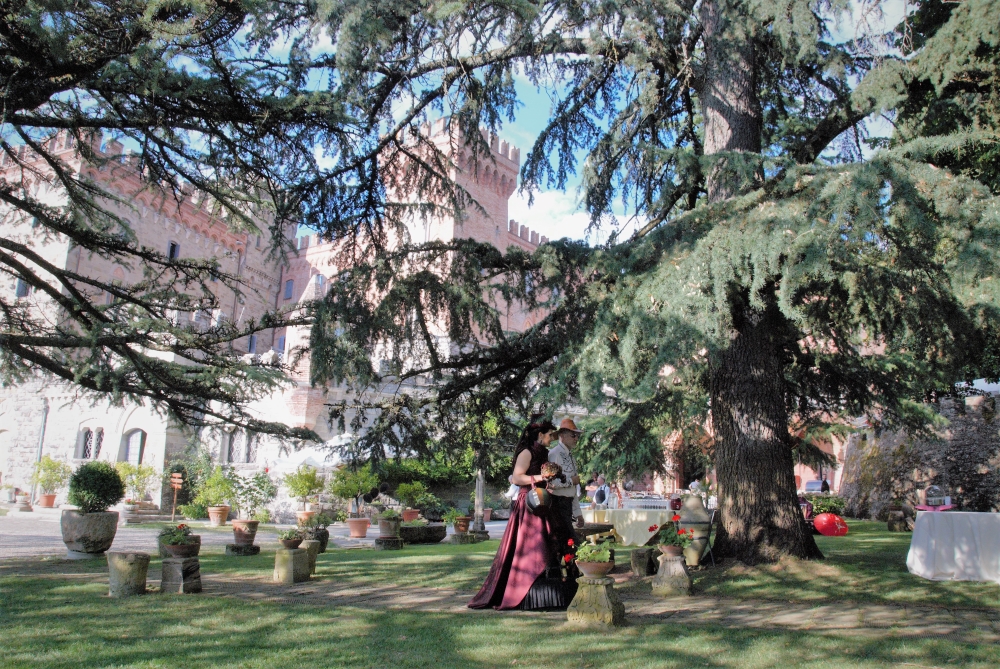 Castle wedding with bride in a steampunk dress, walking with her father to a garden ceremony