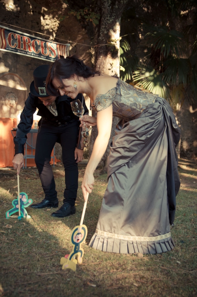 Steampunk dressed woman and man, playing victorian games at an open air wedding