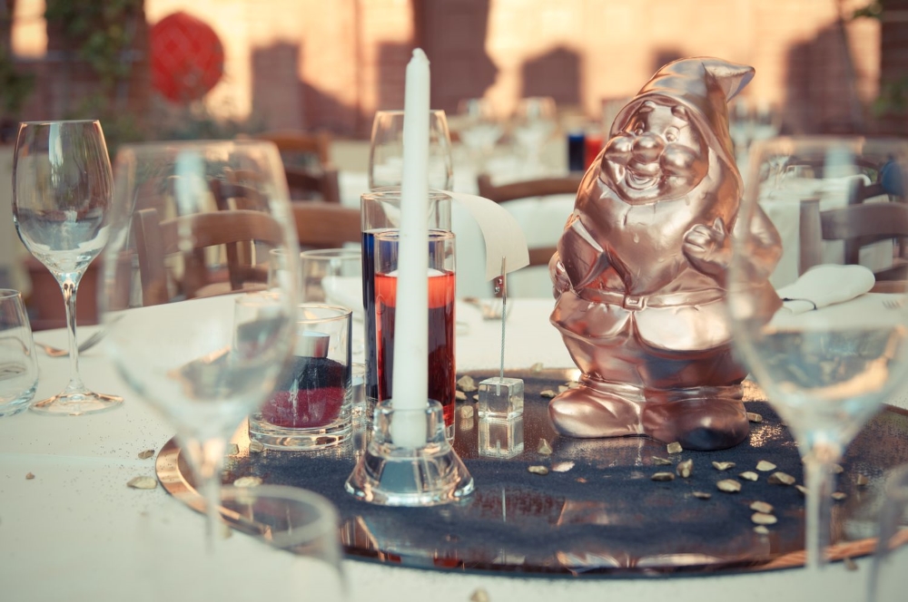 A victorian centerpiece with a bronze dwarf and candles, at a castle wedding