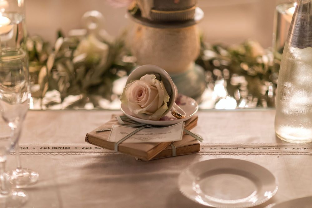 A pink rose in a vintage teacup for an Alice in Wonderland wedding decor