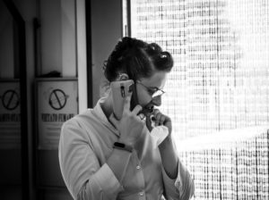 Foto in bianco e nero di una WP pensierosa al telefono che risolve imprevisti di nozze