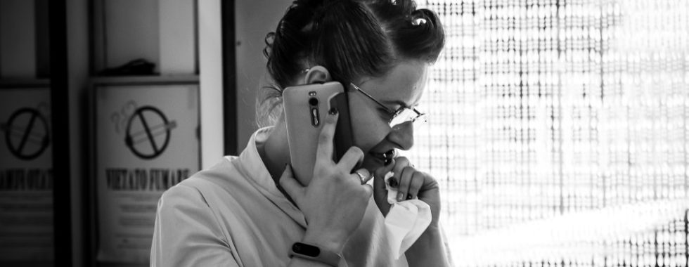 Black and White photo of a thoughtful woman in profile while she's at the phone