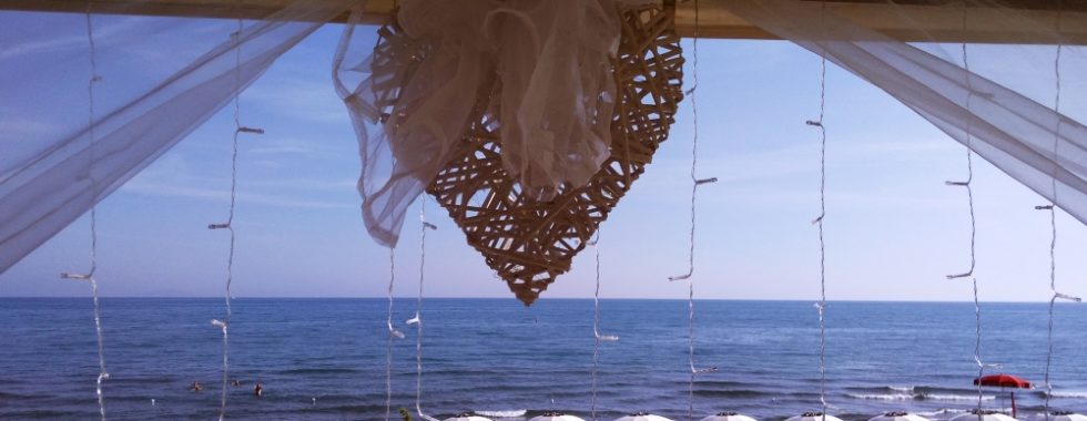 A beautiful view of the Seaside of Castiglione della Pescaia, Framed by tull, fairy lights and a heart, as you'd see on August 15th.