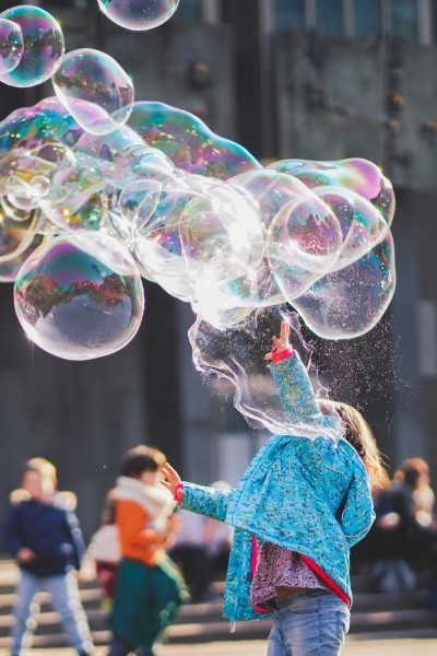 A child plays with giant soap bubbles