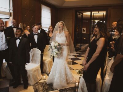 Micro-wedding del 2019, con la sposa che passa tra gli invitati ridendo nella sala della cerimonia